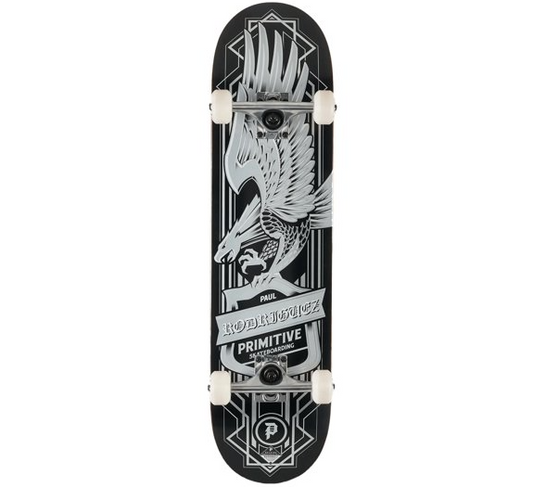 A skateboard deck shown from the underside, featuring a black background with a large white and gray eagle graphic and the text 'PRIMITIVE' and 'WILD AT 20'. The deck is mounted on white wheels with black trucks, photographed against a plain white background.